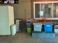 a garage with a refrigerator, trash cans, and other items